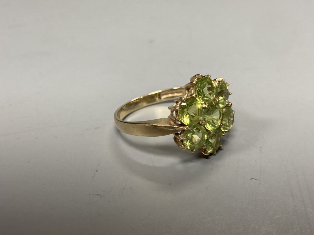 A modern 9ct gold and seven stone peridot cluster ring, size P, gross 3.4 grams.